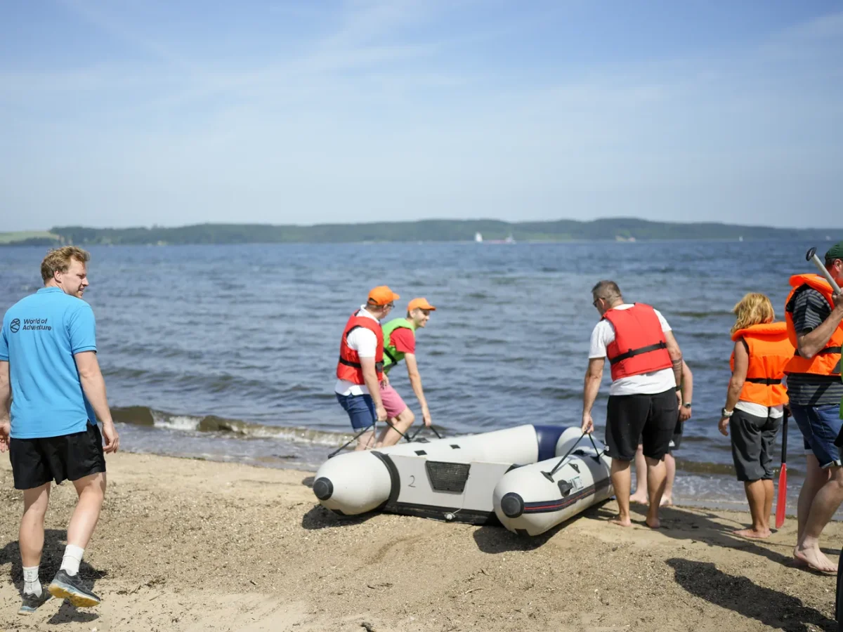 mand gaar paa strand mens gruppe baerer gummibaade