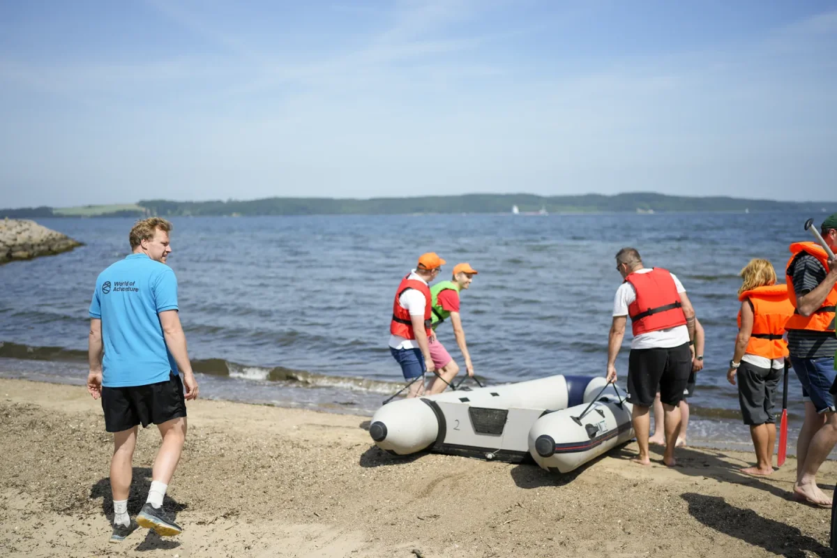 mand gaar paa strand mens gruppe baerer gummibaade