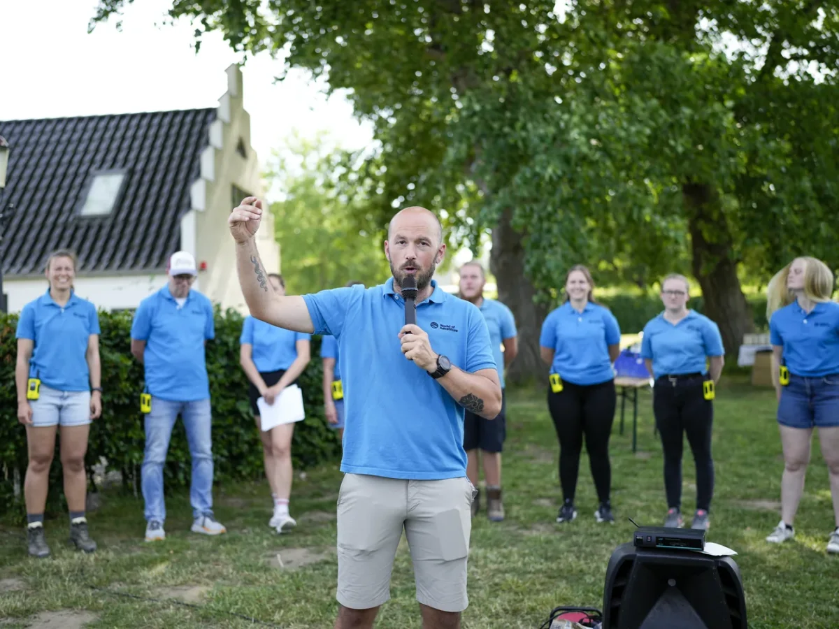 skaldet mand taler og peger op foran slotsbygning
