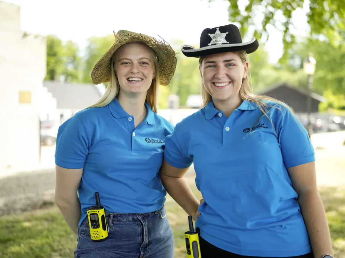 to kvinder i halmhat og sheriffhat smiler