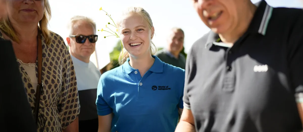 kvinde smiler mens mand kigger ned paa papirer