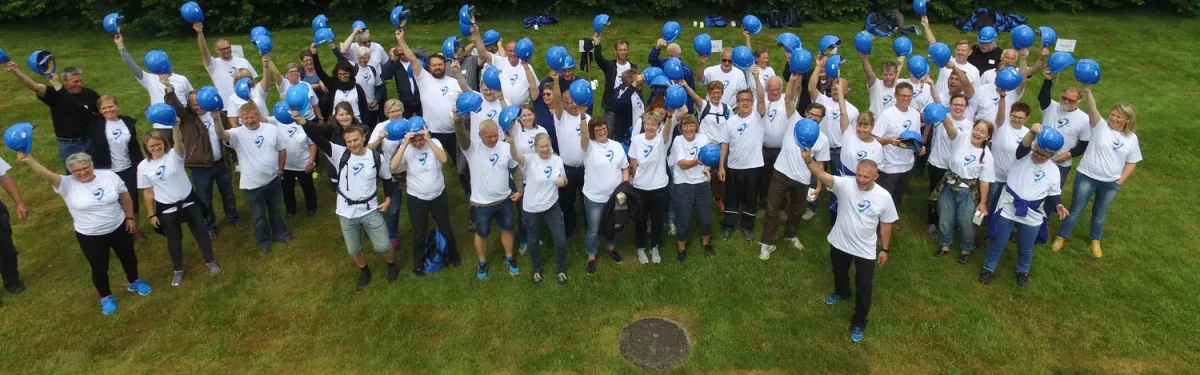 rejsegilde 2 stor gruppe loefter blaa sikkerhedshjelme i vejret