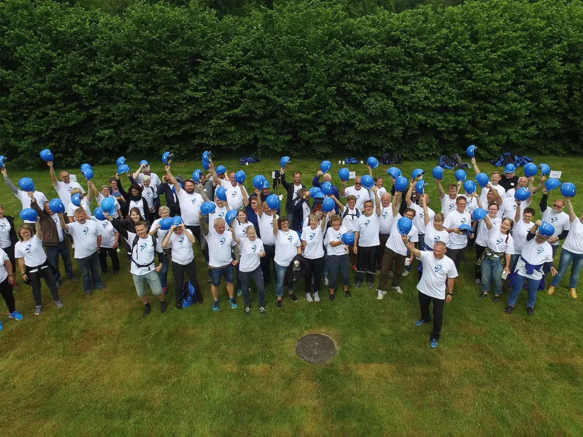 woa stemningsbillede 09 dronefoto af stor gruppe med blaa hjelme paa graesplaene