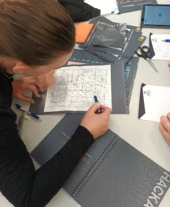 hackathon-deltager-arbejder-papir.webp