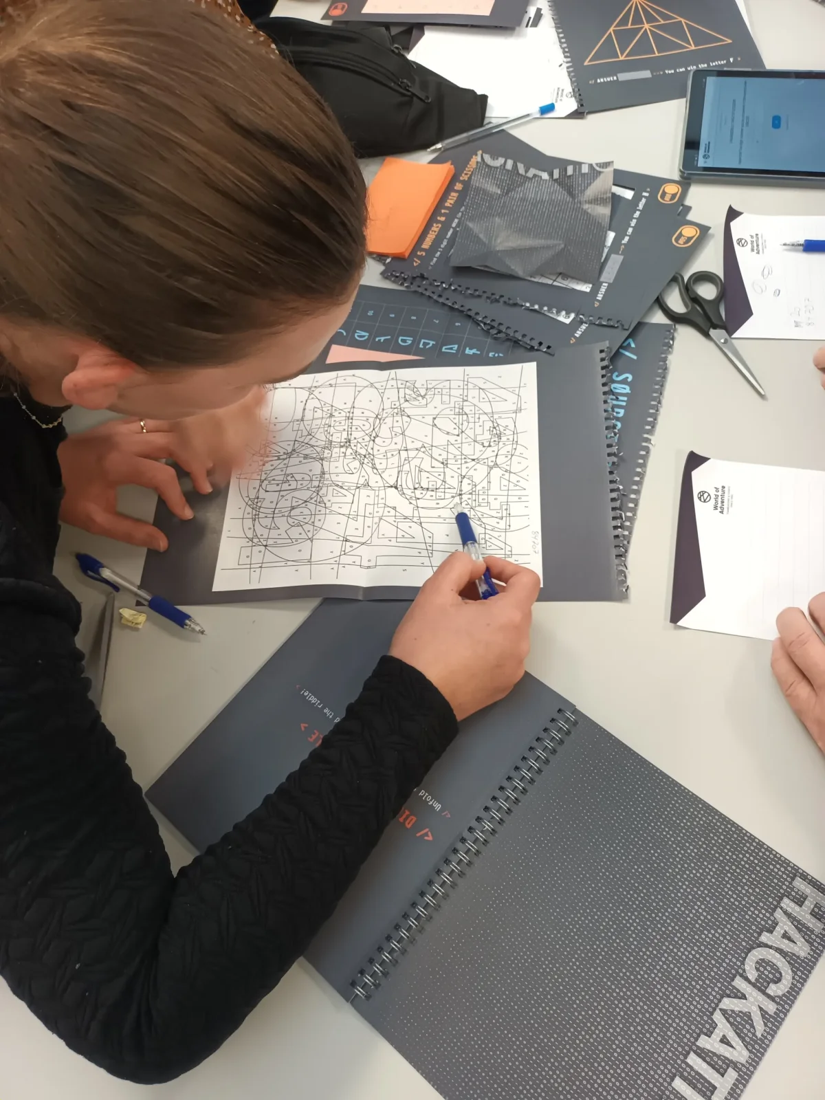 hackathon-deltager-arbejder-papir.webp