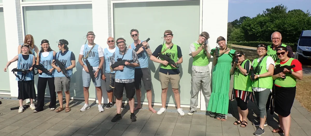 Gruppe deltagere poserer med laser game våben efter aktivitet på Comwell Kellers Park.