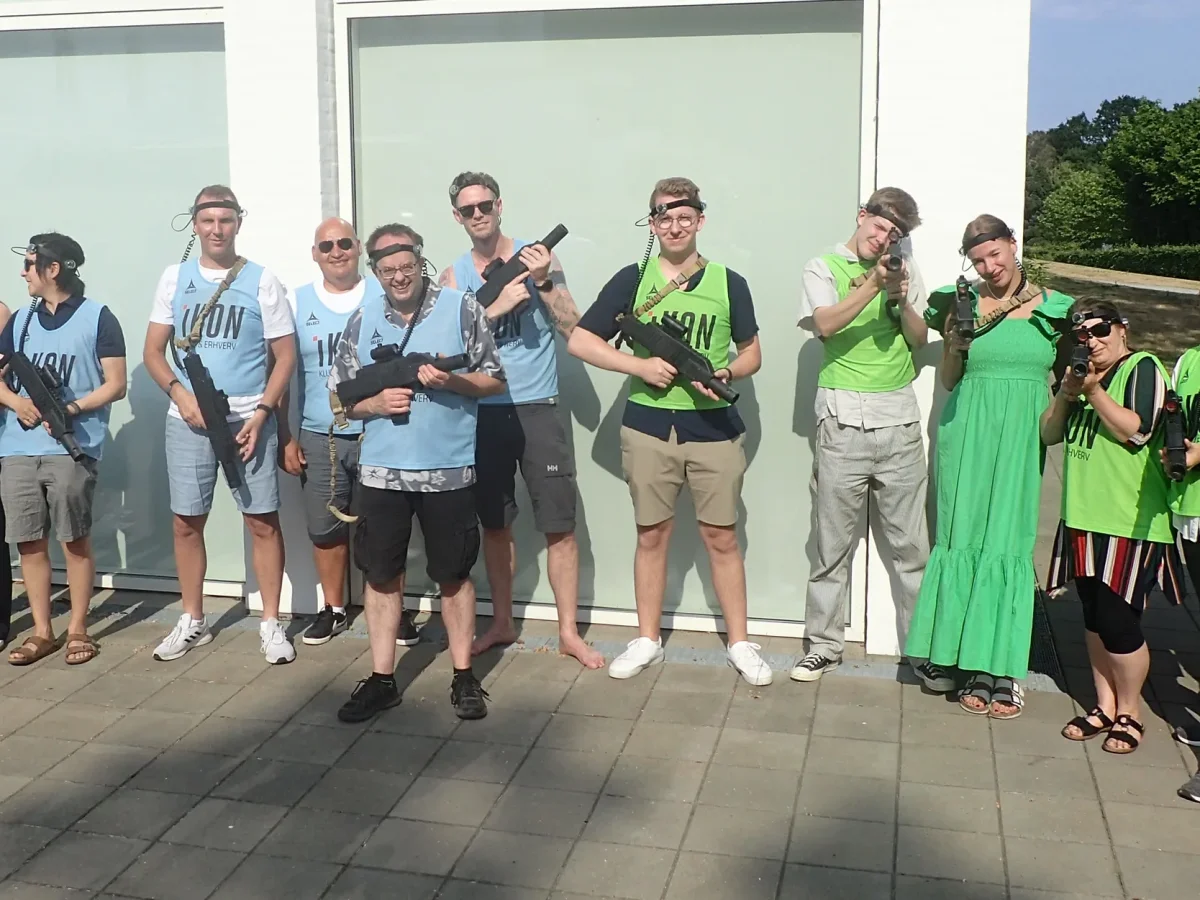 Gruppe deltagere poserer med laser game våben efter aktivitet på Comwell Kellers Park.